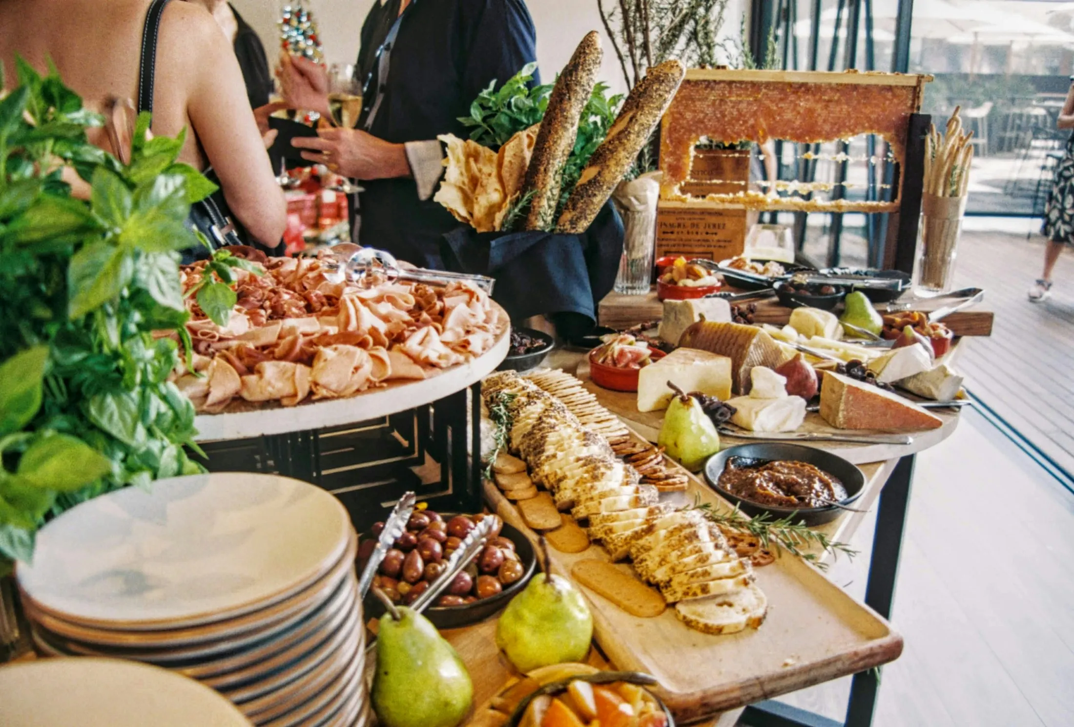 Reich gedeckter Buffettisch mit Brot, Käse und Birnen bei einem Empfang in einem hellen Raum