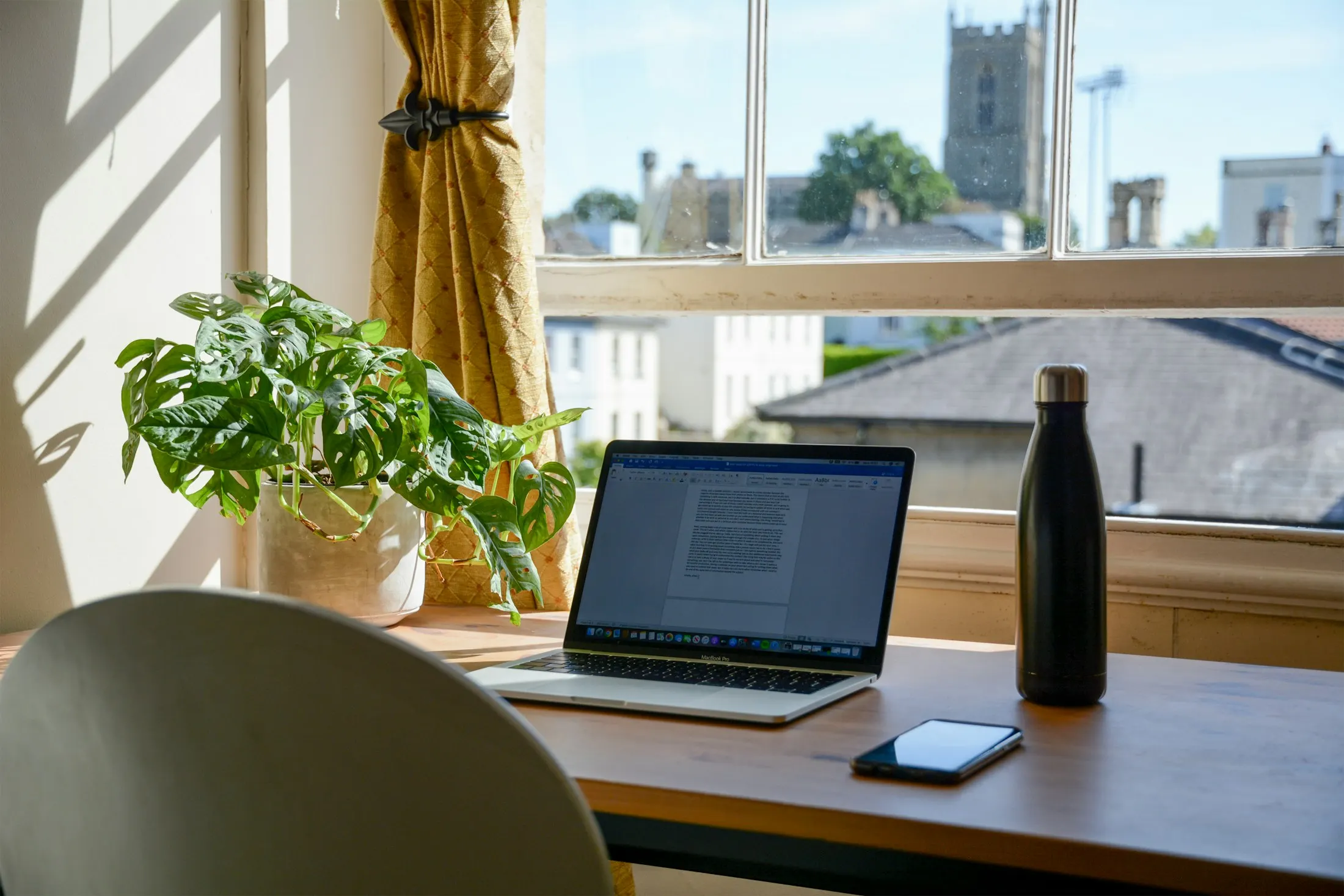 Heller Restaurant-Tresen am Vormittag mit Laptop, Smartphone, Kaffee und Blumen